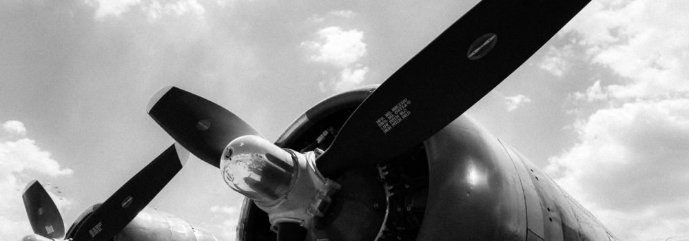 A low angle greyscale shot of two propellers of a plane ready for a takeoff